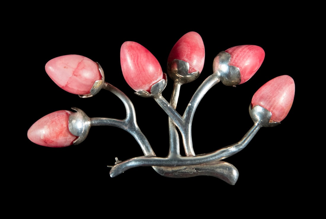 MEXICAN SILVER PINK RHODOCHROSITE BROOCH: MEXICAN SILVER PINK RHODOCHROSITE BROOCH Modernist design, formed as a stylized flowering branch, set with (6) pear-shaped pink rhodochrosite cabochons. Marked Mexico and Silver. 2.18 ozt. tw.
