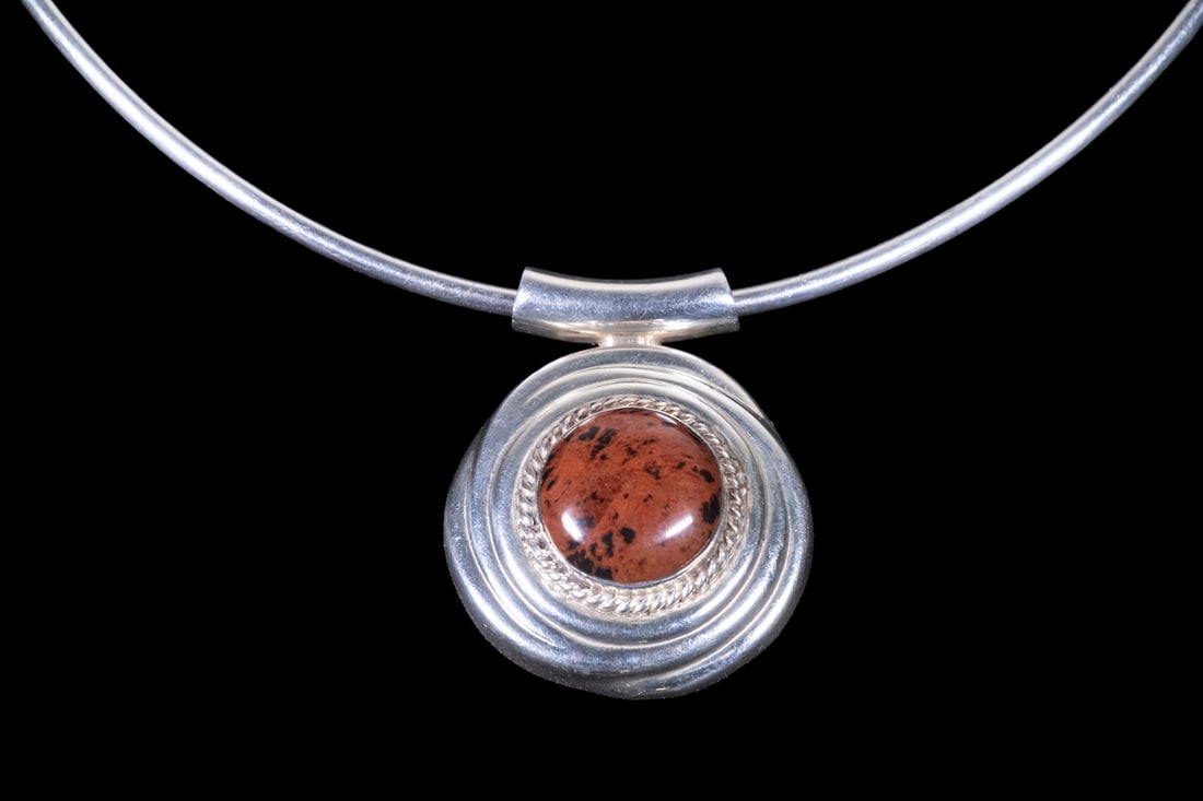 MEXICAN STERLING SILVER JASPER PENDANT TORQUE NECKLACE: MEXICAN STERLING SILVER JASPER PENDANT TORQUE NECKLACE A Mexican sterling silver torque-style necklace featuring a rigid collar with a central pendant set with a round cabochon jasper. The stone displ