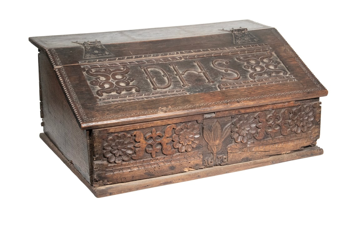17TH C. CARVED OAK BIBLE BOX: 17TH C. CARVED OAK BIBLE BOX Early Slope Top Storage Box, probably English, with carved DHS monogram to the lid, iron butterfly hinges, deep carved floral decoration to lower front panel centered