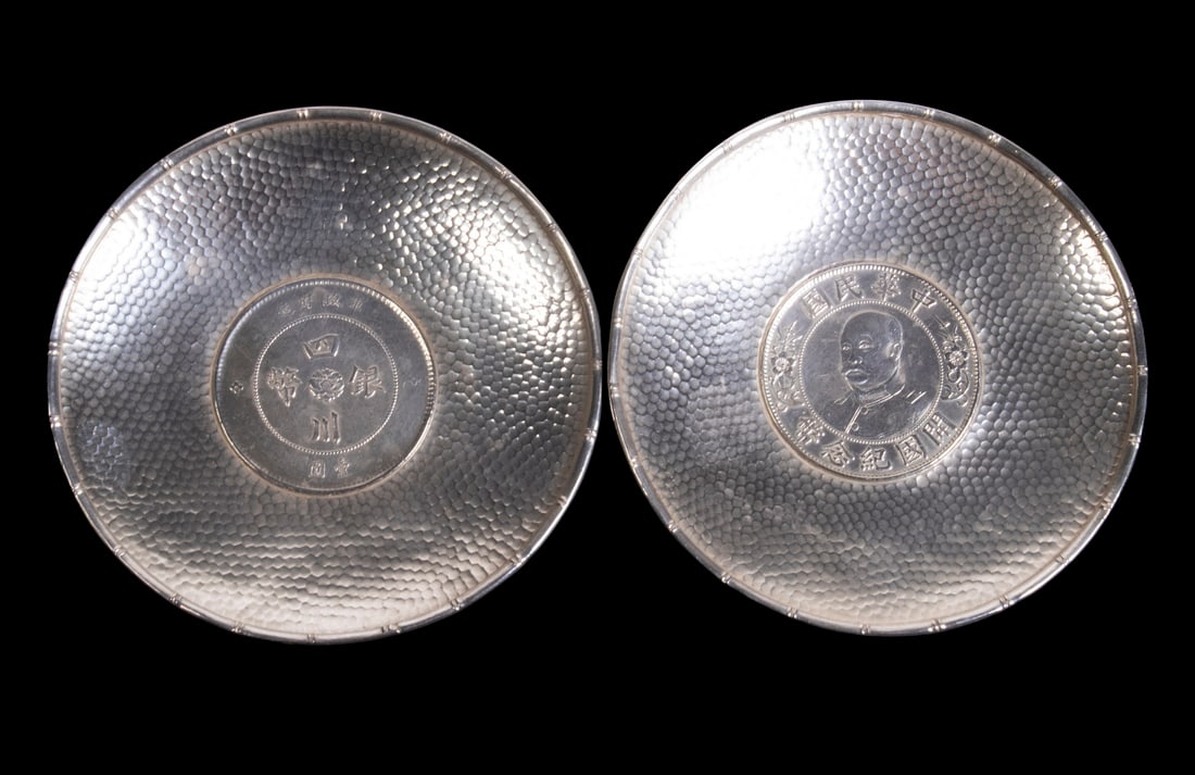 (2) REPUBLIC OF CHINA SILVER PLATES WITH INSET DOLLAR COINS: (2) REPUBLIC OF CHINA SILVER PLATES WITH INSET DOLLAR COINS Lot of (2) Small 950-Silver Pin Dishes, with a hammered surface and bamboo design rim, each centered with a coin -- one with a 1912 Chinese
