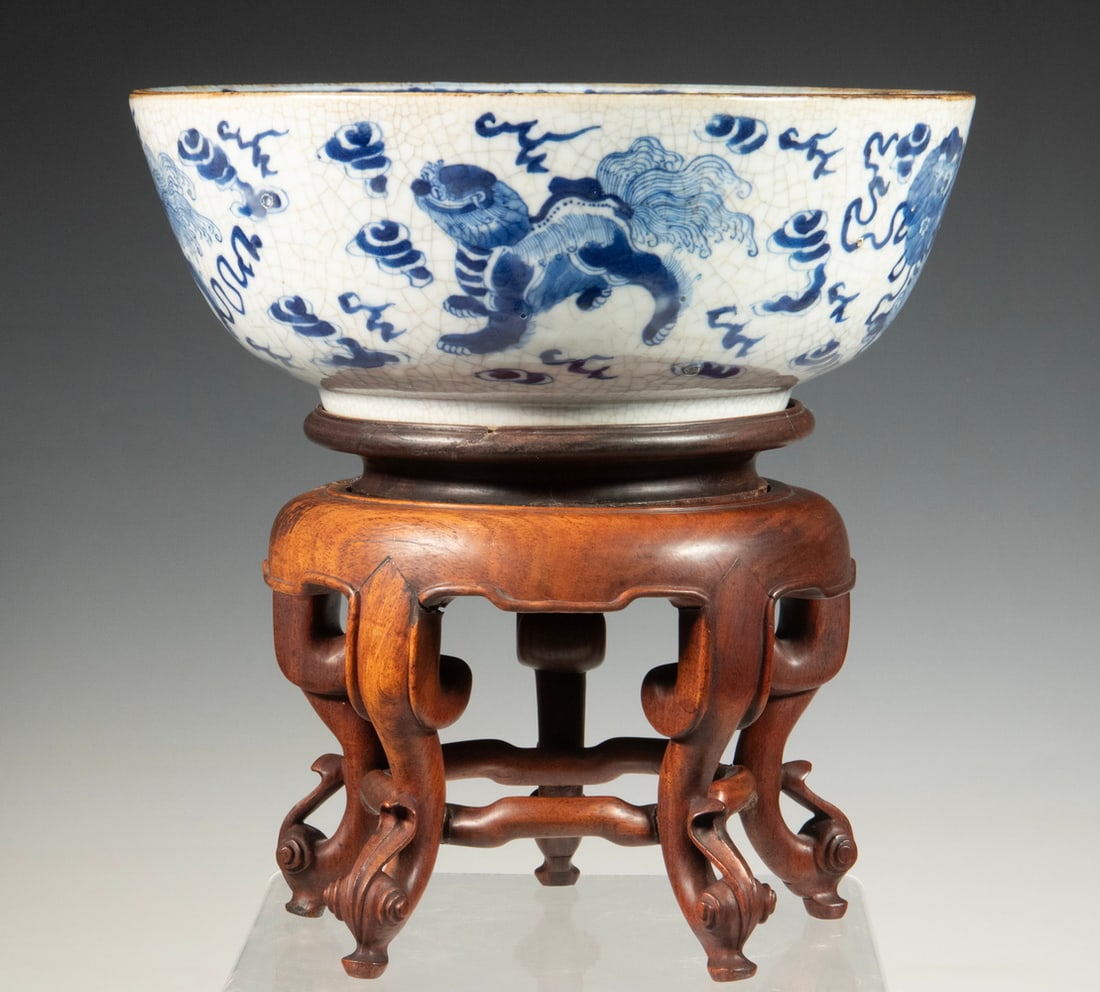 CHINESE BLUE AND WHITE CRACKLE-GLAZED BOWL: CHINESE BLUE AND WHITE CRACKLE-GLAZED BOWL Decorated in underglaze blue with stylized lion masks, clouds, and auspicious symbols beneath a crackle glaze, the interior centered by a roundel enclosing