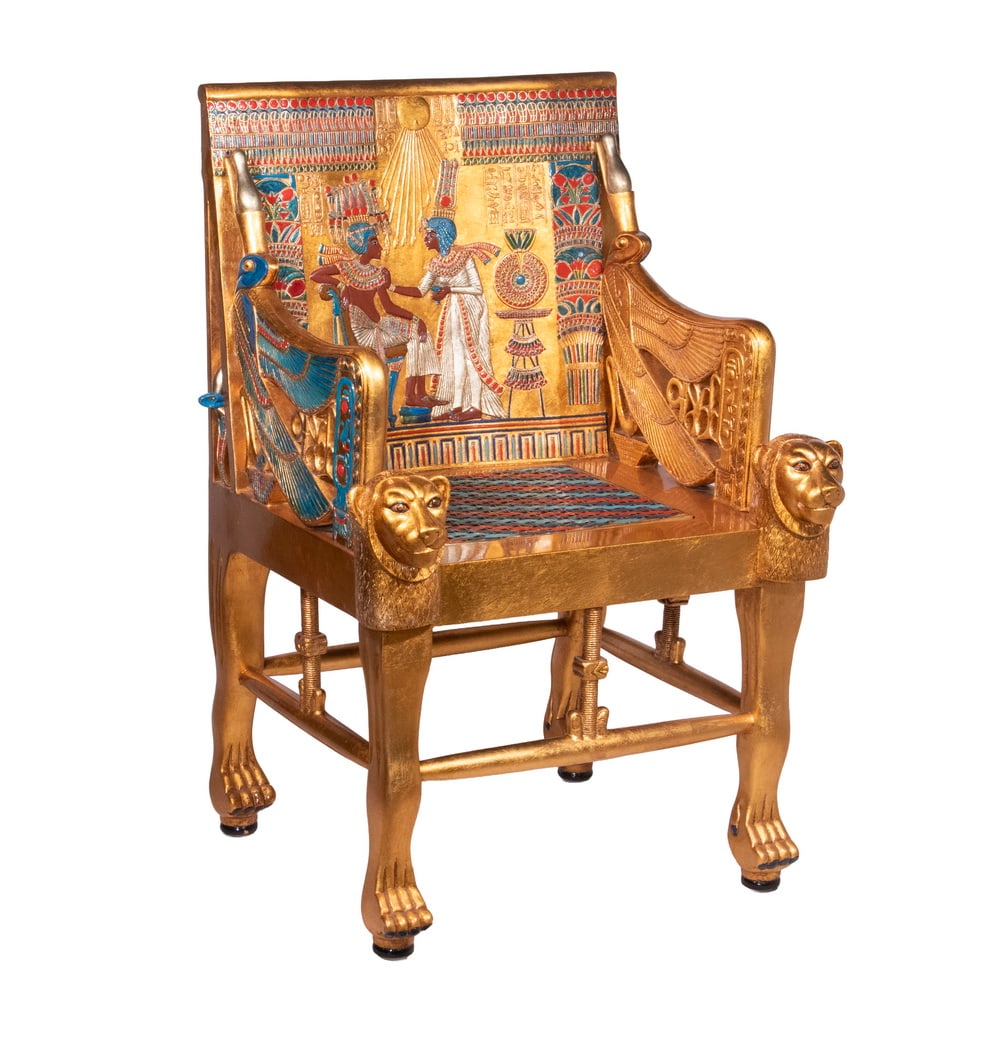 REPLICA TUTHANKAMUN THRONE: REPLICA TUTHANKAMUN THRONE Replica of King Tut's Throne, in relief carved wood and resin with gilding and polychrome, including the woven cane seat, featured Tut as the Sun God Ra in conversation with