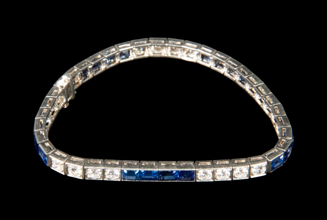 ART DECO 14K GOLD, DIAMOND, AND SAPPHIRE LINE BRACELET: ART DECO 14K GOLD, DIAMOND, AND SAPPHIRE LINE BRACELET An Art Deco 14K white gold bracelet set with alternating sections of round brilliant-cut diamonds and rectangular step-cut blue sapphires. The