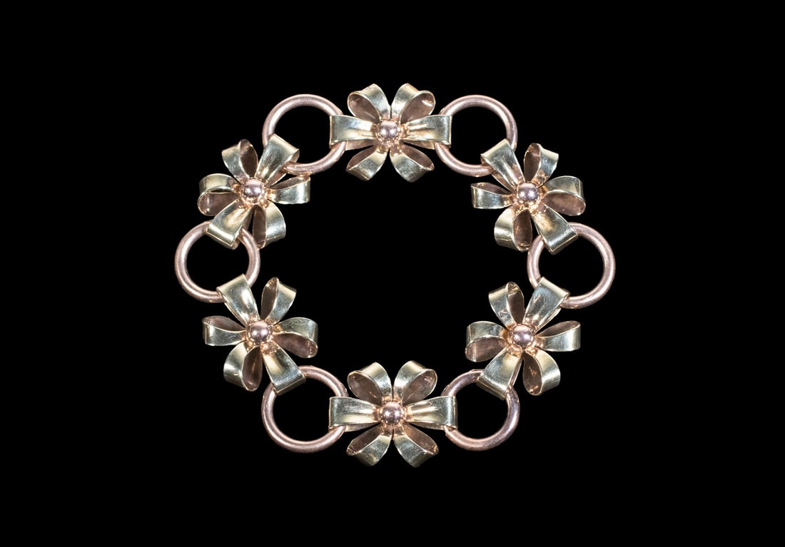 14K TWO-TONE GOLD FLORAL LINK BRACELET: 14K TWO-TONE GOLD FLORAL LINK BRACELET A retro-style two-tone 14K gold bracelet composed of (6) stylized floral yellow links joined by rose gold circular connectors, each flower centered by a polished