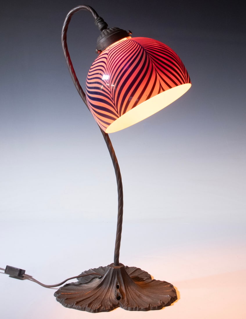 ART NOUVEAU LILY PAD BASE BRONZE TABLE LAMP: ART NOUVEAU LILY PAD BASE BRONZE TABLE LAMP Vintage Gooseneck Lamp, with Quetzal style pulled feather design art glass shade. Unsigned. Single socket fixture taking a candelabra-base bulb, with in-lin