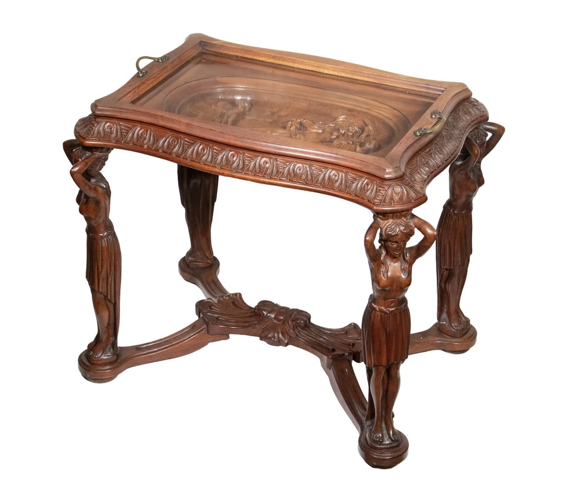 CARVED FIGURAL TRAY TOP TABLE: CARVED FIGURAL TRAY TOP TABLE Vintage Walnut Low Table, having a shaped top, removable tray with glass central panel and brass side handles, with oval relief carving of Venus and putti below, set
