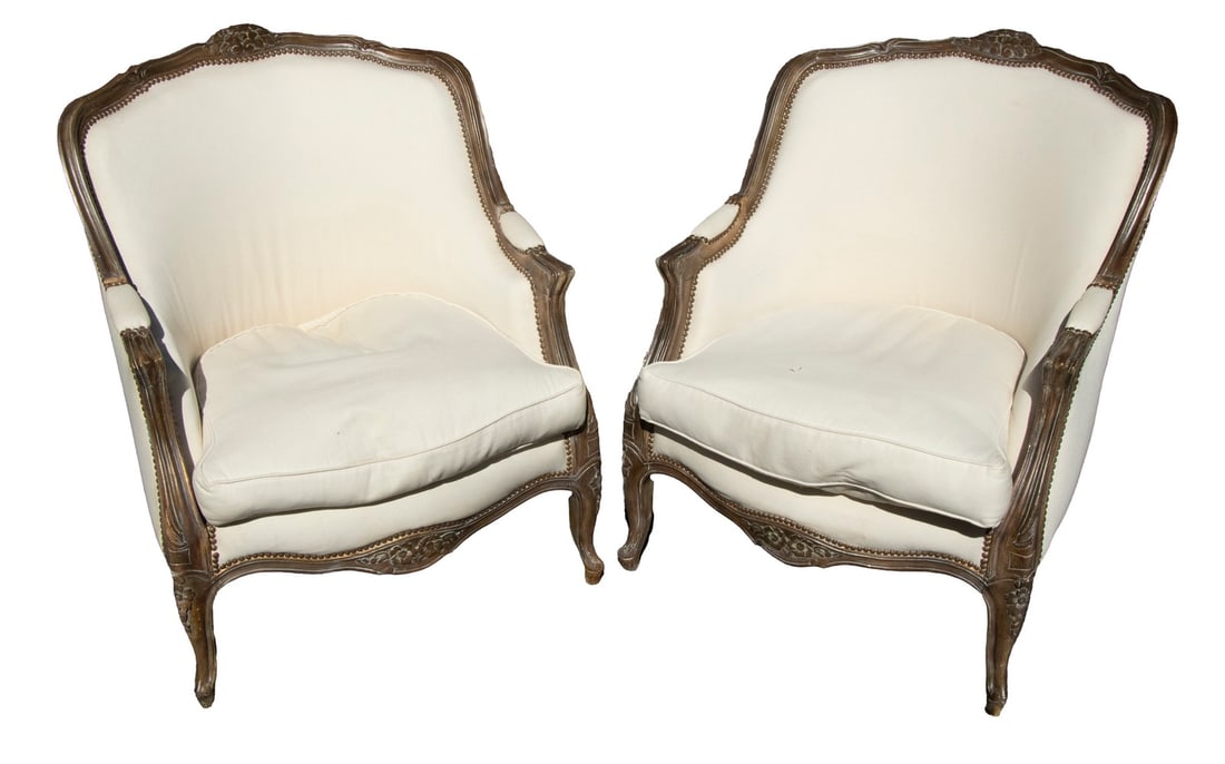 PR LOUIS XV STYLE BERGERE CHAIRS: PR LOUIS XV STYLE BERGERE CHAIRS Pair of French Design Upholstered Armchairs, having carved wooden frames and floral crests, with white cotton duck fabric upholstery. 36 x 28 x 21 1/2 in. (91.4 x 71.1