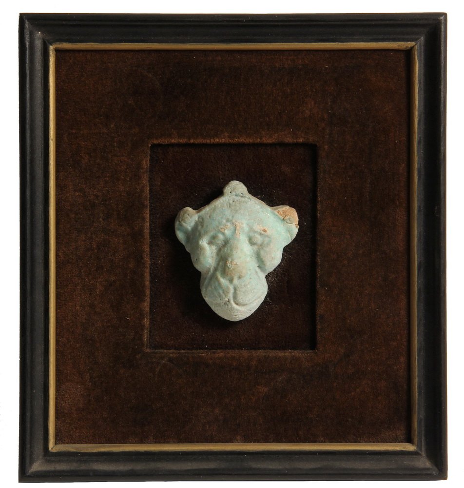 ANCIENT EGYPTIAN FAIENCE - Burial Fetish of a Lioness: ANCIENT EGYPTIAN FAIENCE - Burial Fetish of a Lioness Head, Middle Kingdom, mounted on velvet background, framed. 2 3/4" tall, 9" x 8" frame. Loss to right ear, surface of brow.