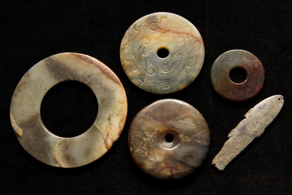 (5) ANCIENT CHINESE JADES - Warring States Burial: (5) ANCIENT CHINESE JADES - Warring States Burial Fetishes, including four bi discs and a fish pendant, one disc is incised. 1 5/8" to 3 1/2". Worn, as expected.