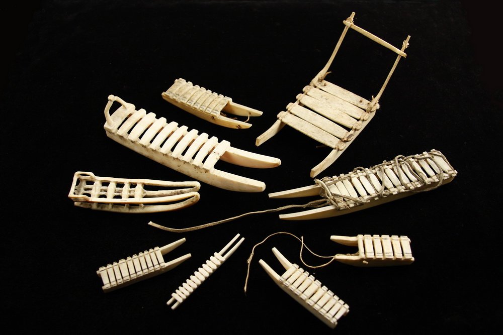 (9) ESKIMO CARVINGS - Bone or Ivory Carved Sled Models,: (9) ESKIMO CARVINGS - Bone or Ivory Carved Sled Models, some with rawhide bindings, ranging in size from 2 3/8" to 6 1/4" long, minor damages.