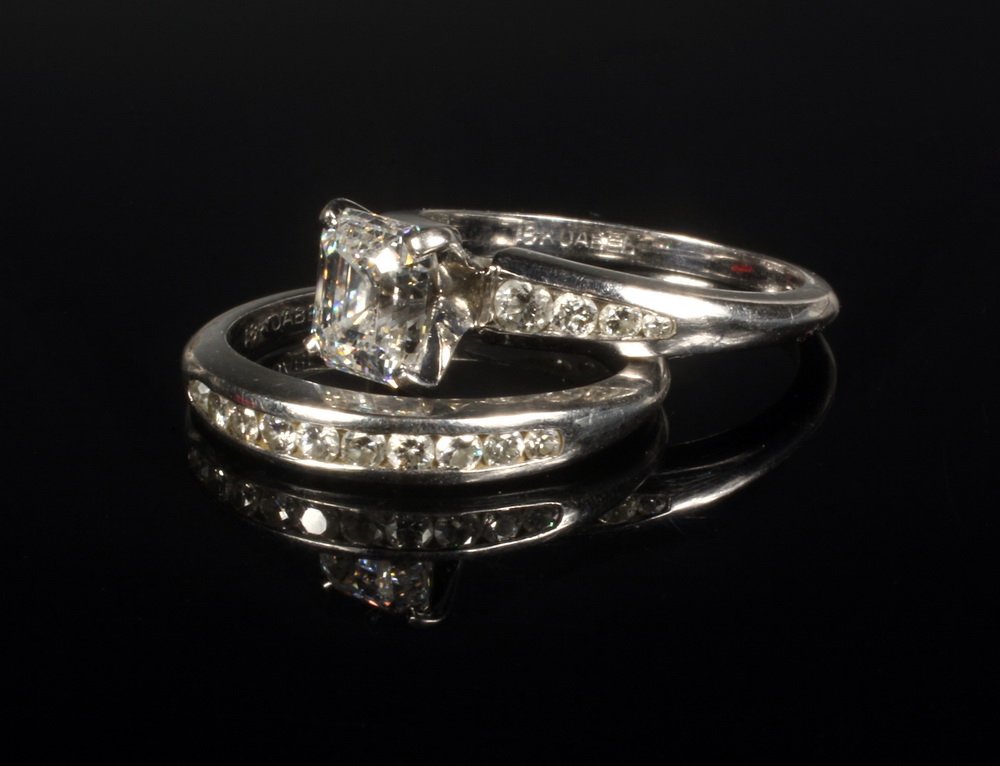 LADY'S WEDDING SET - Two-part Engagement and Wedding: LADY'S WEDDING SET - Two-part Engagement and Wedding Band Set in 18K white gold, setting marked '18K Jabel', centered by an antique emerald cut diamond flanked by (8) graduating round diamonds. (1) Em