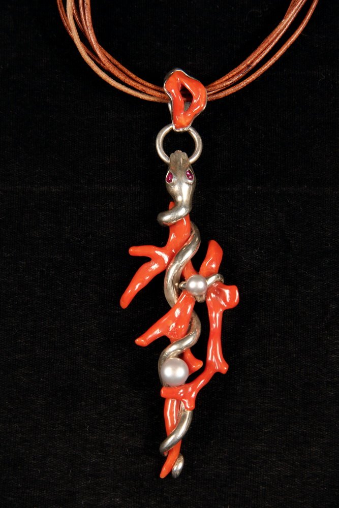 DESIGNER PENDANT - Custom, One-of-a-Kind, Sterling: DESIGNER PENDANT - Custom, One-of-a-Kind, Sterling Mounted Red Coral Snake Form Pendant with (2) grey pearls and ruby eyes on brown leather cord, signed Tonis. 5" x 1 3/4". Fine condition.