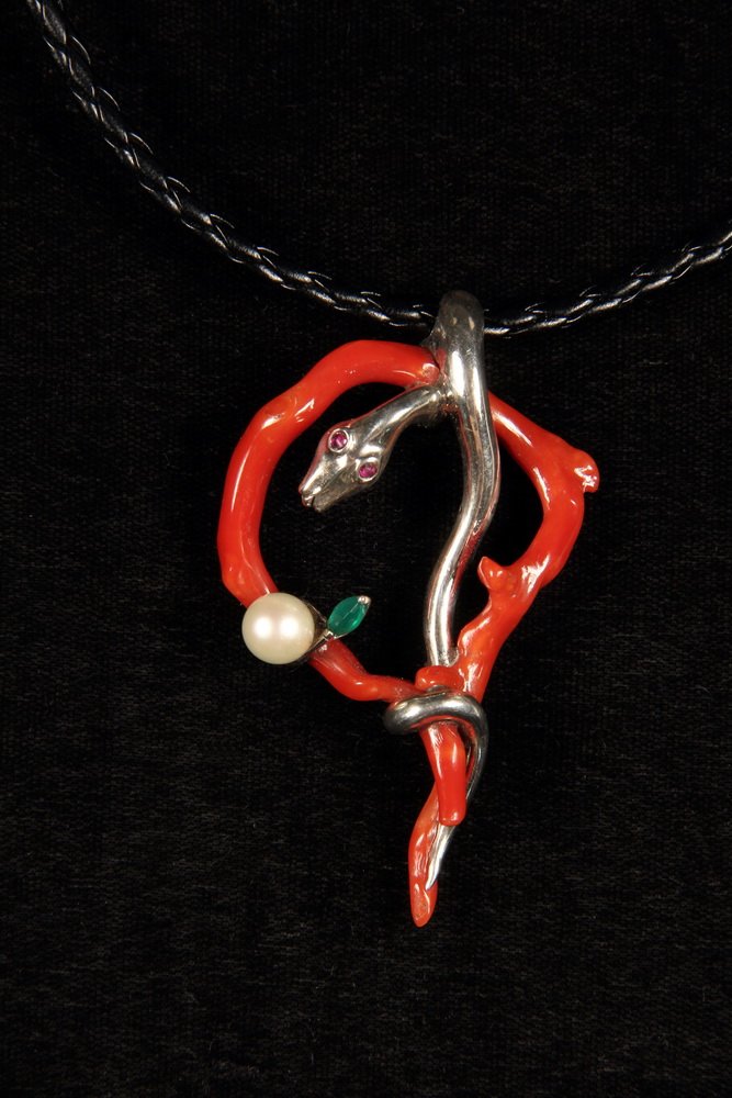 DESIGNER PENDANT - Custom, one-of-a-kind Red Coral and: DESIGNER PENDANT - Custom, one-of-a-kind Red Coral and Sterling Snake Form Pendant, with ruby eyes, set with emerald and pearl, by Tonis. On black woven leather cord. 3" long x 1 5/8" wide. Fine condi