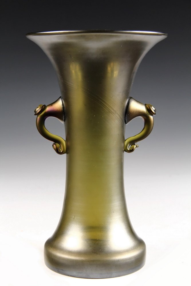 ART GLASS VASE - Greek Form Two-Handled Vase in rare: ART GLASS VASE - Greek Form Two-Handled Vase in rare iridescent copper green color, having flared rim, scrolled arms with floral buttons, squared foot, ground pontil. Possibly Loetz. Circa 1900. 9 1/4