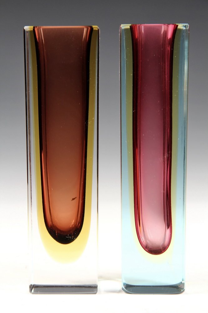 (2) ART GLASS STEM VASES - Mold Blown Crystal Oblong: (2) ART GLASS STEM VASES - Mold Blown Crystal Oblong Vases in similar form & color, one in pale blue, the other in clear, both with cranberry colored pockets couched in amber. 8" tall. Very good condi