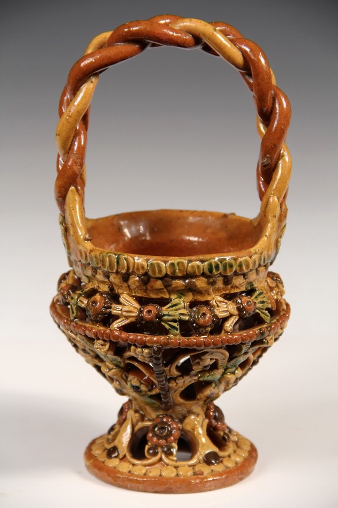 RARE BAVARIAN REDWARE BASKET - Kroning, ca 1880,: RARE BAVARIAN REDWARE BASKET - Kroning, ca 1880, Three-Glazed Pottery with pretzel braided handle, shallow bowl within floral reticulated stand. Rare form. 8" tall. Fine condition.