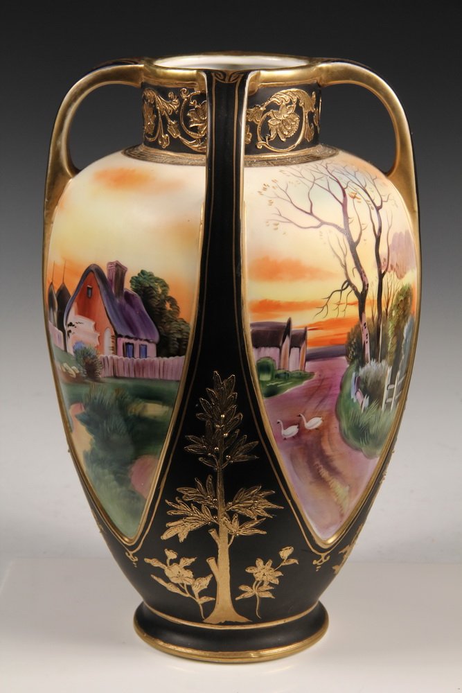 LARGE NIPPON PORCELAIN VASE - Four Handled Vase in: LARGE NIPPON PORCELAIN VASE - Four Handled Vase in black with gold, having four landscape panels that are contiguous, depicting a lakeside European village. 12 3/4" tall, 7 1/2" diam. Fine condition.