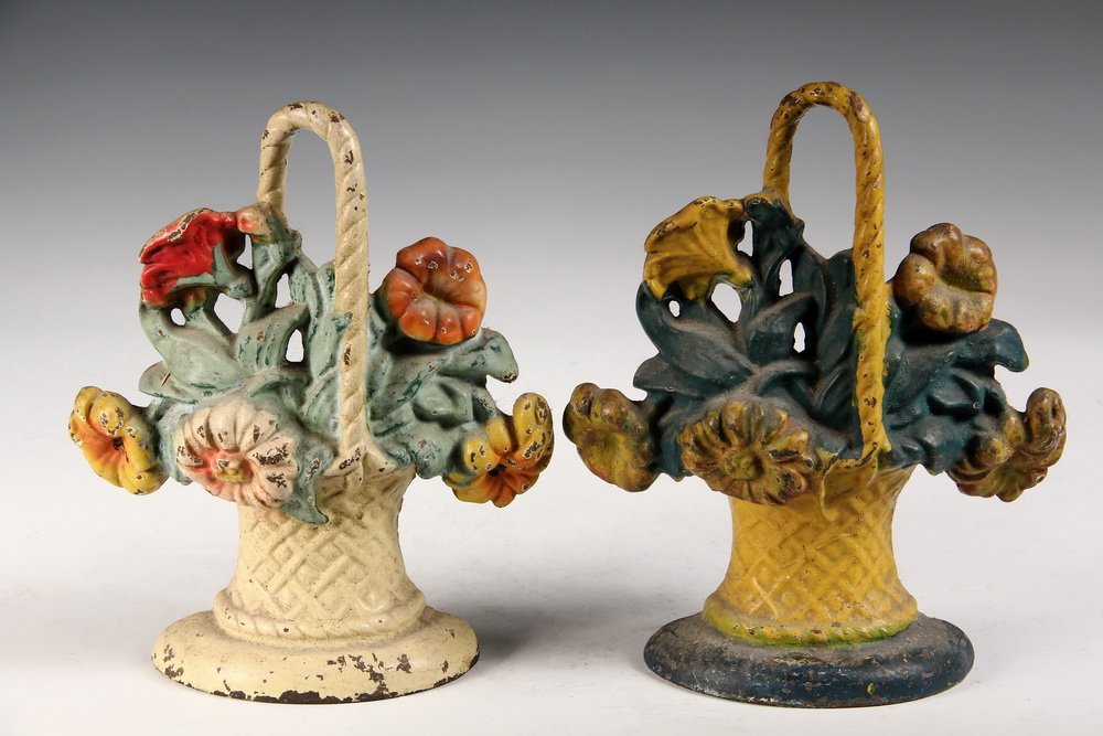 PAIR OF CAST IRON DOORSTOPS - Painted Iron Door Stops: PAIR OF CAST IRON DOORSTOPS - Painted Iron Door Stops in the form of Flower Baskets, same castings, in different paint schemes. Circa 1900. 9 1/2" tall. Some paint loss.