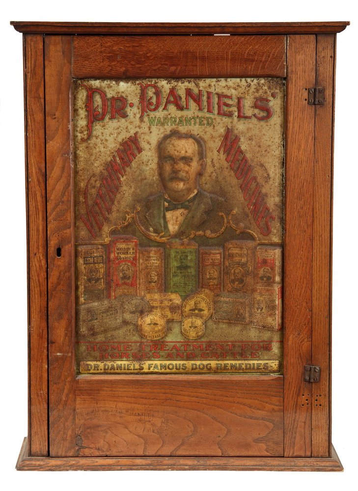 VET ADVERTISING CABINET - Circa 1910 Oak Cabinet with: VET ADVERTISING CABINET - Circa 1910 Oak Cabinet with tin litho sign for "Dr. Daniels' Warranted Veterinarian Medicines", molded top and bottom, three internal shelves. Lock but no key. "Home Treatmen