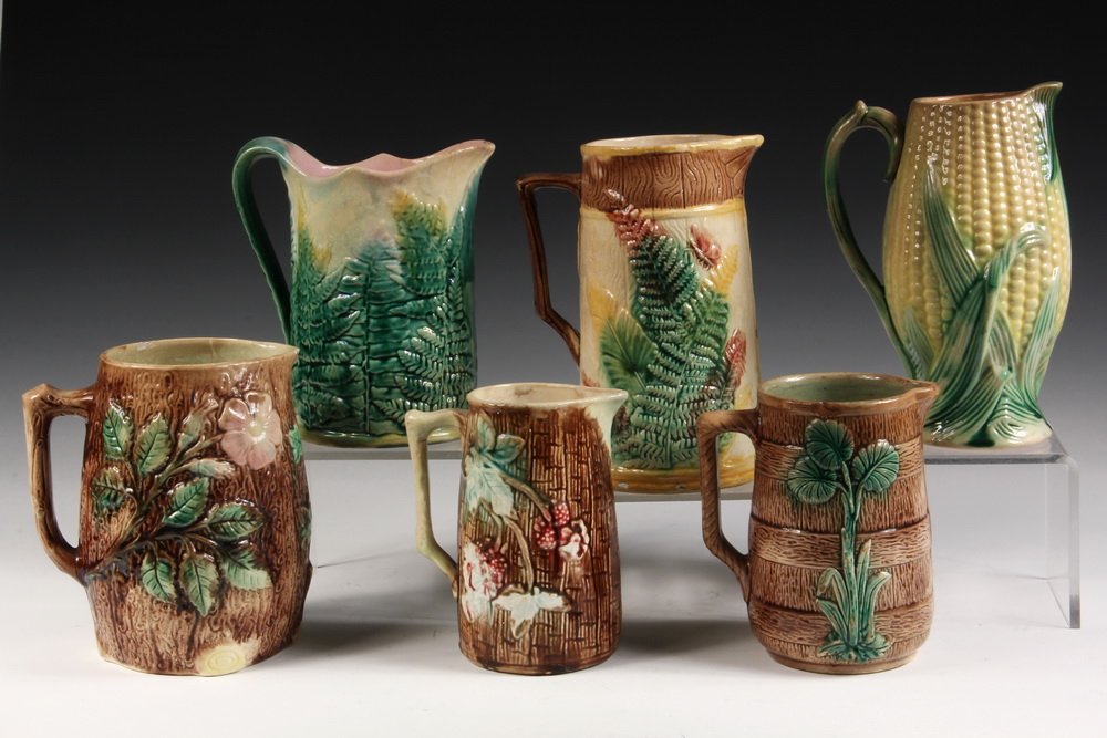 (6) MAJOLICA PITCHERS - Including: Stag Pitcher; Corn: (6) MAJOLICA PITCHERS - Including: Stag Pitcher; Corn Pitcher; Apple Blossom & Log; Etruscan Fern by Griffin, Smith & Hill; Fern on Fence; Barrel & Leaf. 6" to 8 1/4". All have some damage.