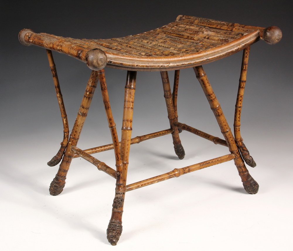 BAMBOO STOOL - Scorched Bamboo Stool in Egyptian: BAMBOO STOOL - Scorched Bamboo Stool in Egyptian Revival form, with concave seat, diagonal braces and legs ending in root balls. Circa 1890. 18" x 20" x 17". One knuckle missing off end of rail.