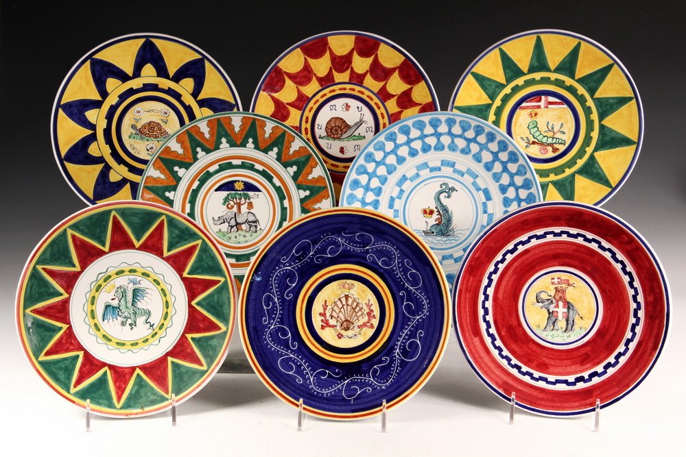 (8) ITALIAN FAIENCE PLATES - Decorative Wall-Hanging: (8) ITALIAN FAIENCE PLATES - Decorative Wall-Hanging Plates marked 'Siena', each handpainted with a different faux and humorous heraldic crest, and in various brlliant color schemes. 9 3/4" diam. Fine
