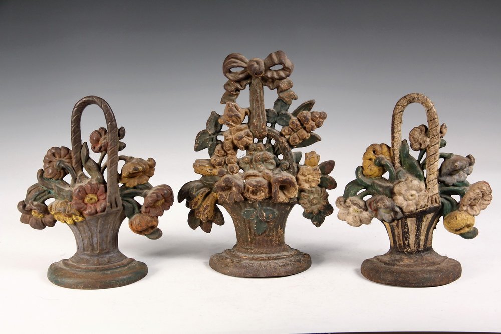 (3) CAST IRON DOORSTOPS - Painted Iron Flower Basket: (3) CAST IRON DOORSTOPS - Painted Iron Flower Basket Form Door Stops, circa 1900. 9" to10 1/2" tall. Some paint loss.