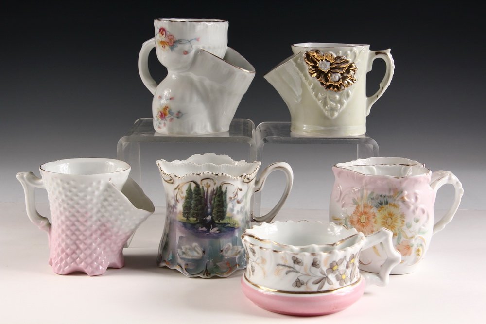 (6) EUROPEAN SHAVING MUGS W/ SOAP HOLDERS - Inc: RS: (6) EUROPEAN SHAVING MUGS W/ SOAP HOLDERS - Inc: RS Prussia handpainted swans; Bavarian floral w/ cinched waist; Unmarked heart-shaped; Unmarked cream & gilt floral; Raised diamond pink; Low floral. 2