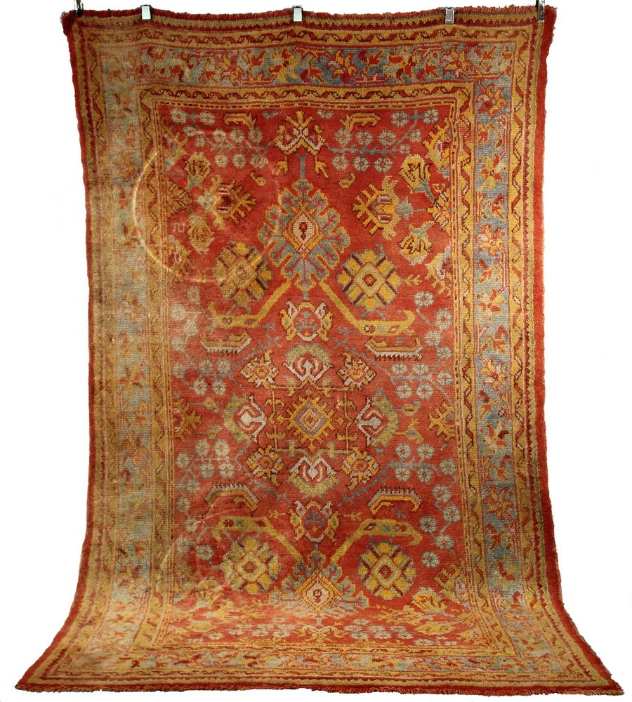 USHAK CARPET - 6'2" X 10'2" - West Anatolia, second: USHAK CARPET - 6'2" X 10'2" - West Anatolia, second quarter 20th c, overall design with palmettes, rosettes, curved leaves and diamonds in gold, sky blue, orange and tan. Set on a red field, sky blue 