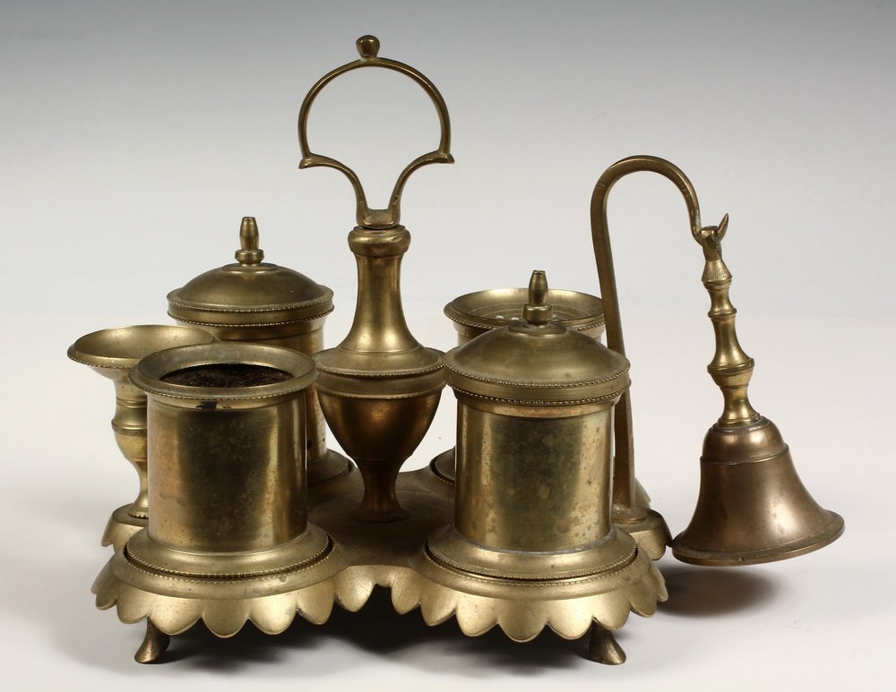 SPANISH DESK STANDISH - Late 18th c. Cast Brass Writing: SPANISH DESK STANDISH - Late 18th c. Cast Brass Writing Stand with two covered cups, sander, open cup, candle holder and snuffer around handle, set on shaped and scalloped base, on feet. Cf. "The Bras