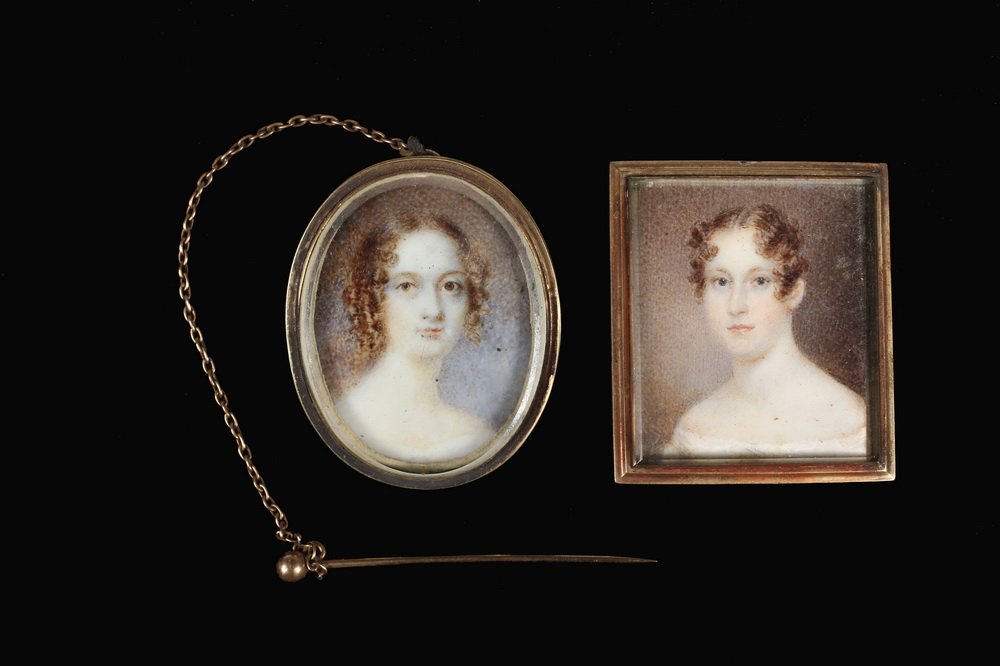 (2) MINIATURE PORTRAIT BROOCHES - Both circa 1830: (2) MINIATURE PORTRAIT BROOCHES - Both circa 1830 Portraits of Lovely Young Ladies, in gold filled mounts with swing pins and glass lenses, the oval is oil on ivory and has a chained collar pin; the o