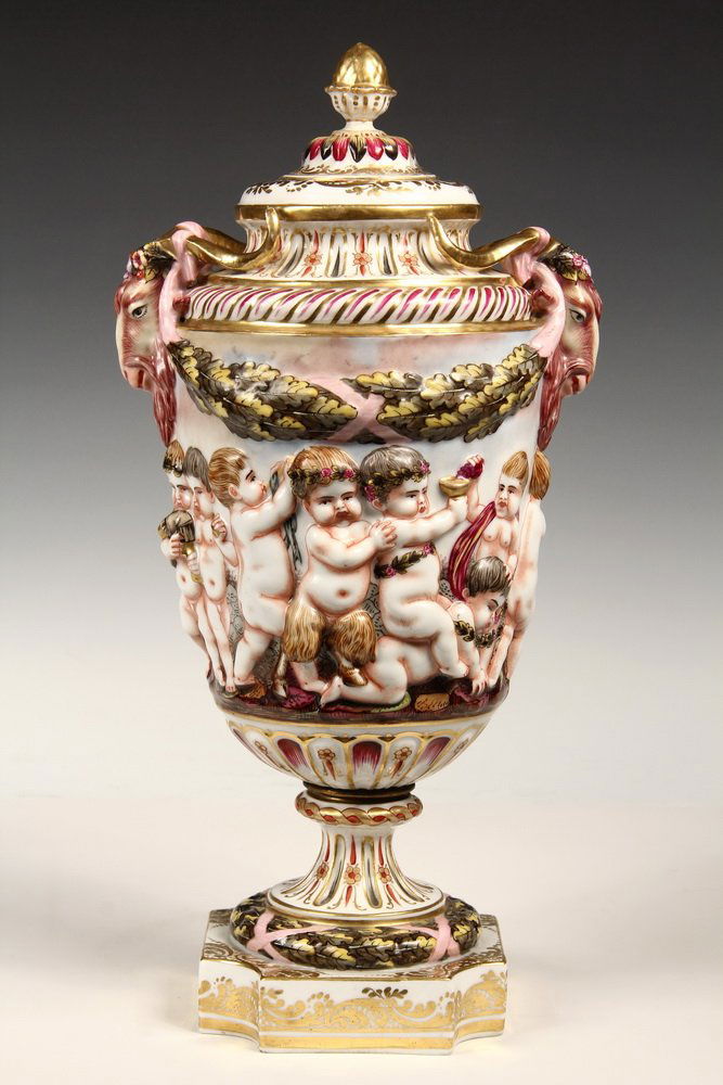 LARGE CAPODIMONTE URN - Covered Urn with inverted acorn: LARGE CAPODIMONTE URN - Covered Urn with inverted acorn finial, ram's head handles, acorn leaf swags, frieze of cavorting cherubs & satyrs, set on acorn leaf wreath, square inset gilt base, N crown ma