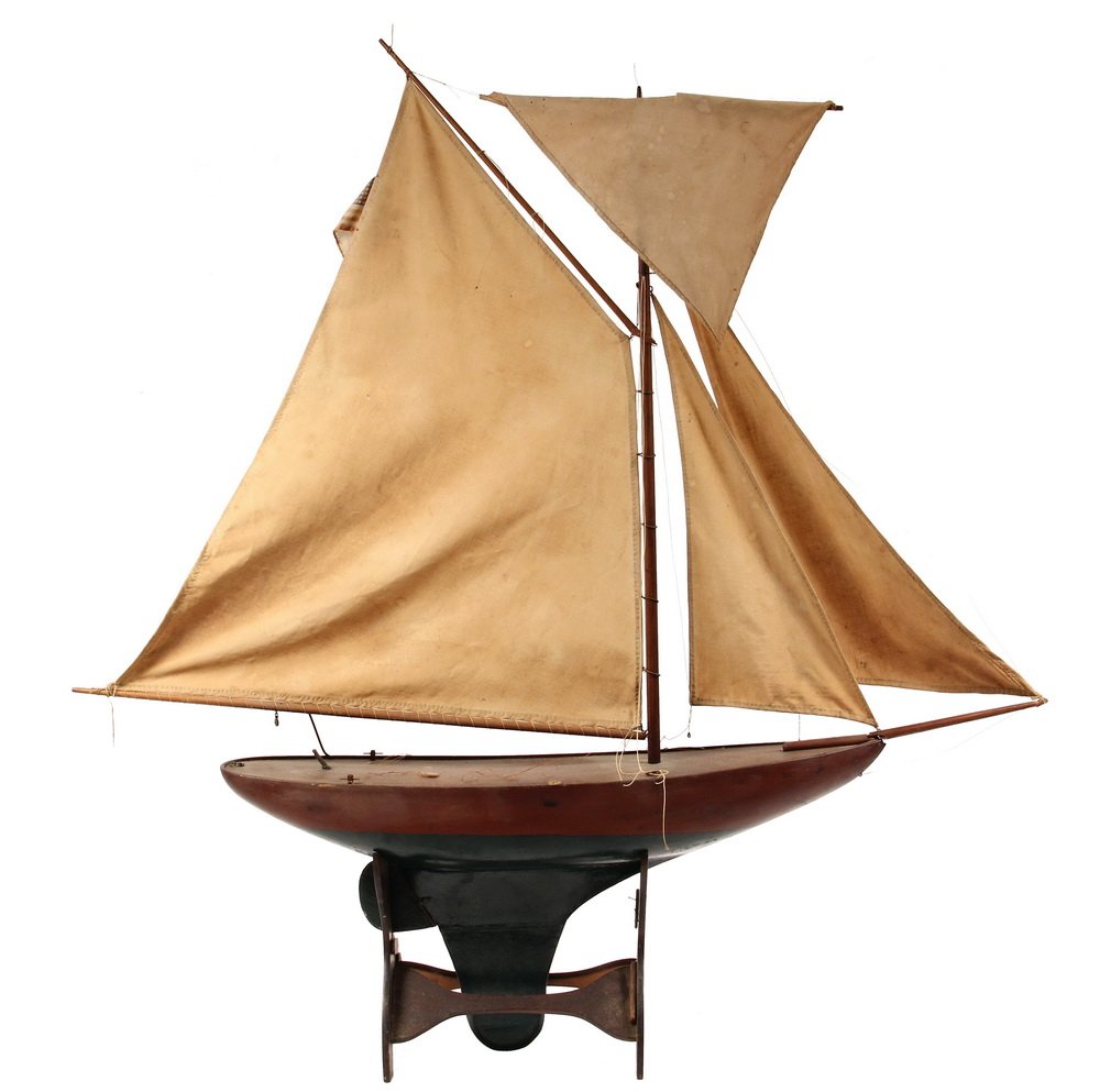 POND MODEL - Late 19th c. Sailing Model with a hollow: POND MODEL - Late 19th c. Sailing Model with a hollow mahogany hull, painted green below the waterline, weighted keel, with full set of original sails. On period stand. Broken bowsprit. 24" long.