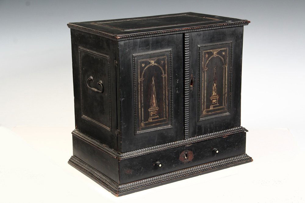 VARGUENO TABLE CABINET - 18th c.Continental Small Scale: VARGUENO TABLE CABINET - 18th c.Continental Small Scale Cabinet in ebonized wood with bone inlay, having ripple molding, drop handles on sides, an inlaid obelisk centered on both doors, single drawer