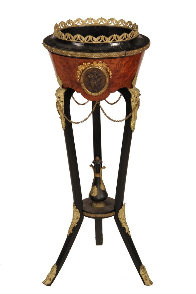 EMPIRE PERIOD WINE COOLER - French Black Lacquer and: EMPIRE PERIOD WINE COOLER - French Black Lacquer and Mahogany Cooler on Tripod Base, with gilt ormolu mounts including a gallery rim, oval frames with bronze relief plaques of cherubs, gryphon head le
