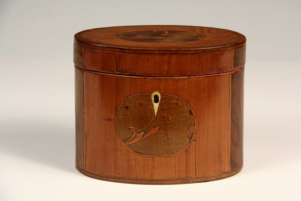 FEDERAL PERIOD TEA CADDY - Oval Caddy in Fruitwood,: FEDERAL PERIOD TEA CADDY - Oval Caddy in Fruitwood, with string inlaid banding, green stained paneled ends and matching cartouches with boxwood scrollwork, inverted teardrop escutcheon. The interior r