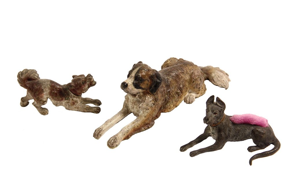 (3) AUSTRIAN BRONZE FIGURES - Cold Painted Dogs,: (3) AUSTRIAN BRONZE FIGURES - Cold Painted Dogs, including: a Barking Terrier, a Reclining Saint Bernard and a Reclining Great Dane (with pin cushion back). 5 3/4" to 2 3/4" long. Some wear to paint.