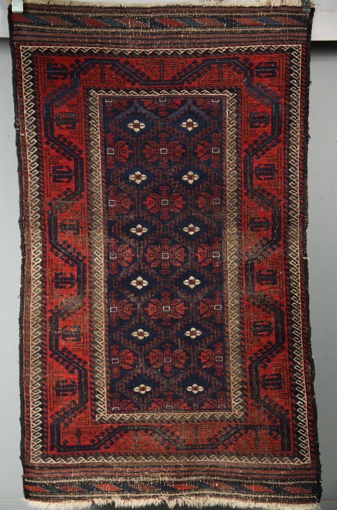 ORIENTAL RUG - 3' x 5'2" - Baluch Area Rug, Northeast: ORIENTAL RUG - 3' x 5'2" - Baluch Area Rug, Northeast Persia, late 19th c, diamond lattice of quatrefoil motifs in rust and ivory on navy blue field, rust boat border, even wear throughout.