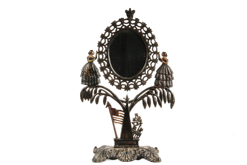 JENNY LIND CAST IRON DRESSING MIRROR WITH UNUSUAL: JENNY LIND CAST IRON DRESSING MIRROR WITH UNUSUAL VARIATION - Vintage late 19th c. Cast Iron Tabletop Mirror Stand featuring the American flag and shield at base, the oval mirror supported by opposing