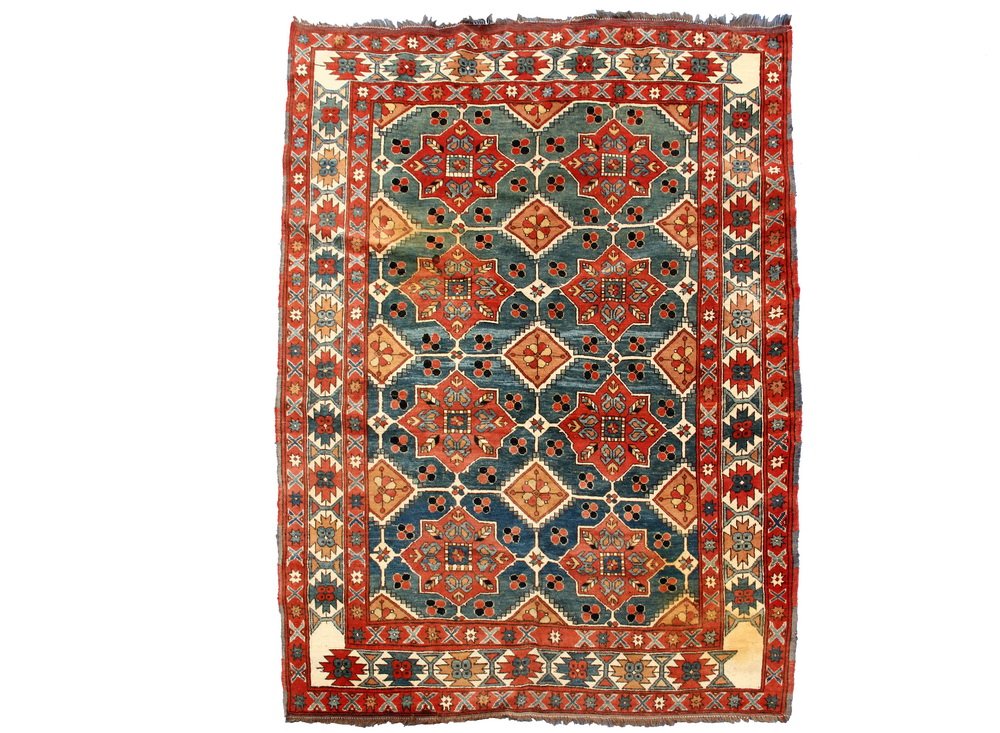KAZAK RUG - 5'9" X 6'9" - Southwest Caucasus, mid 20th: KAZAK RUG - 5'9" X 6'9" - Southwest Caucasus, mid 20th c, with two columns of eight square gabled rust medallions. Set on an abrashed slate blue field decorated with diamonds and rosettes, ivory polyg