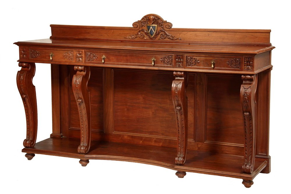 MONUMENTAL GILDED AGE CREDENZA - American Red Walnut,: MONUMENTAL GILDED AGE CREDENZA - American Red Walnut, with painted carved heraldic shield on backsplash, molded top over three drawers, open base with four Renaissance revival carved scroll legs, mold
