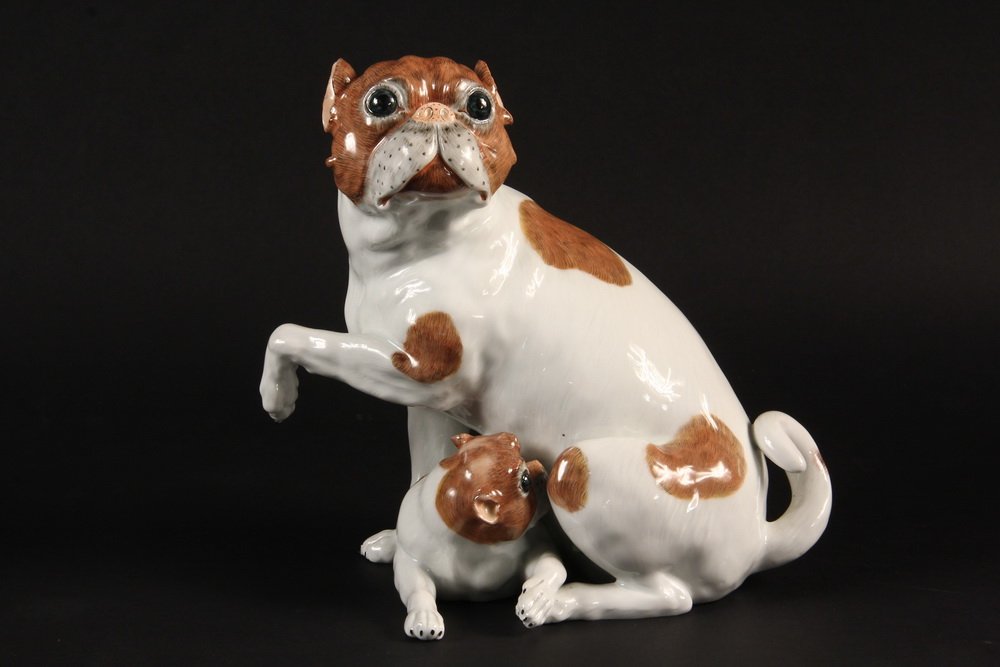 PUG FIGURINE - Carl Thieme Dresden Figurine Depicting a: PUG FIGURINE - Carl Thieme Dresden Figurine Depicting a Mother Pug Dog and Puppy, early 20th Century. Handcrafted piece made in Potschappel, Germany, circa 1901, marked near tail with Thieme's blue un