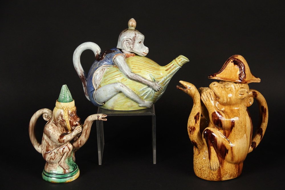 (3) TEAPOTS - Collection of (3) Majolica Figural Monkey: (3) TEAPOTS - Collection of (3) Majolica Figural Monkey Form Teapots. Including: teapot depicting a monkey with a serpent form spout and green pointed hat, unmarked, 8 3/4" high, 7 1/2" wide, chips to
