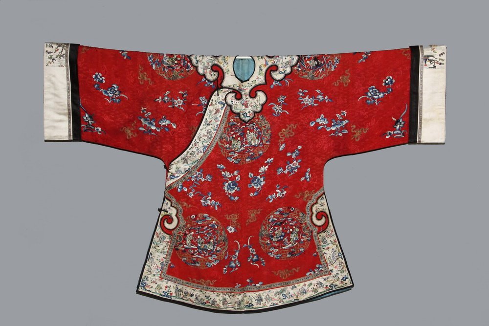 CHINESE ROBE - Lady's Formal Robe, Late Qing, circa: CHINESE ROBE - Lady's Formal Robe, Late Qing, circa 1890, in fine crimson silk figured damask, with embroidered decoration of repeating medallions containing women in gardens, flanked by dragon and ph