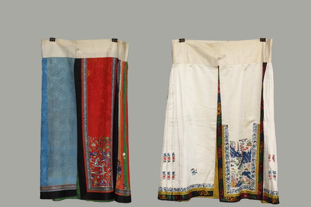 (2) CHINESE SKIRTS - Summer Skirt, late Qing, circa: (2) CHINESE SKIRTS - Summer Skirt, late Qing, circa 1900, in multi-colored pillow pleats with embroidered scattered blossoms, central crimson panel in figured damask with embroidered figures in garden