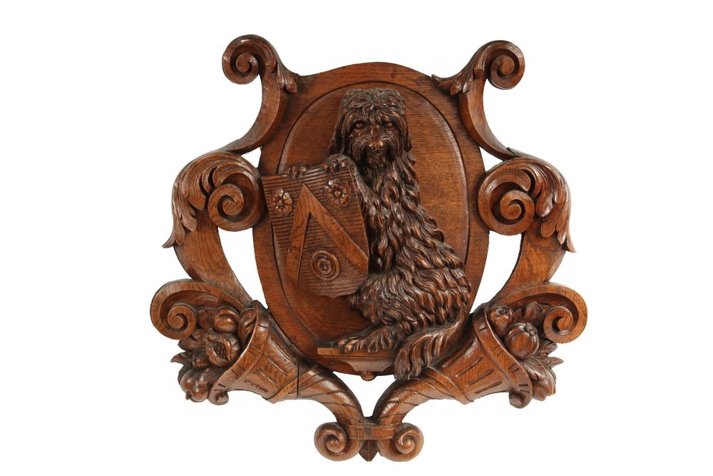VICTORIAN HERALDIC CARVING - Carved Oak Armorial: VICTORIAN HERALDIC CARVING - Carved Oak Armorial Cartouche, with an oval reserve depicting a seated terrier dog holding a shield, flanked by cornucopia and scrollwork, 23" x 23", tip of one upper leaf