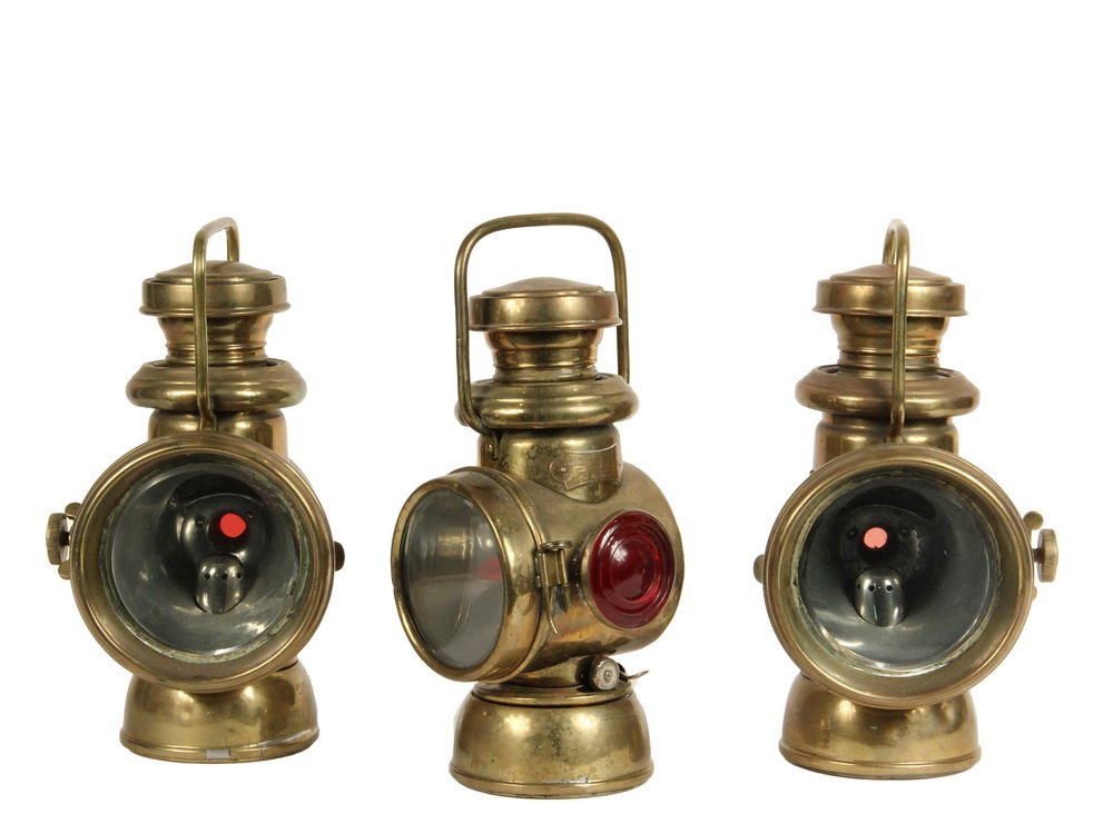 PAIR & SINGLE AUTOMOBILE HEADLAMPS - Powell & Hanmer: PAIR & SINGLE AUTOMOBILE HEADLAMPS - Powell & Hanmer Brass Kerosene Lamps, manufactured in Birmingham, England; having hoop handles, opposing side bracket mounts, 3 3/4" beveled edge flat lenses over 