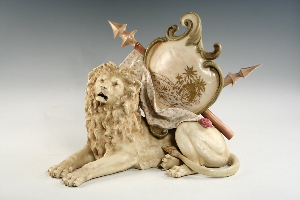 FIGURAL PORCELAIN JARDINIERE - Reclining Regal Lion by: FIGURAL PORCELAIN JARDINIERE - Reclining Regal Lion by New York & Rudolstadt, with 'RW' in shield and '3709' impressed on bottom, 'Germany' in blue circle; the beast is depicted in cream body with sha