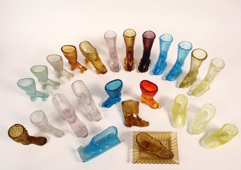 (25) RARE MINIATURE SHOES IN PRESSED GLASS - Including:: (25) RARE MINIATURE SHOES IN PRESSED GLASS - Including: (7) Tall Ladies Boots, two in ice blue, one clear, one amber, one aubergine, two vaseline, all 5 1/2" tall; (4) Tall Ladies Roller Skates, two p
