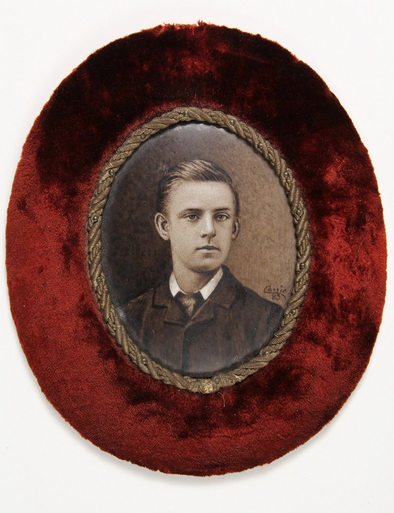 PORTRAIT MINIATURE - Depicting a Young Man, sepia on: PORTRAIT MINIATURE - Depicting a Young Man, sepia on porcelain, signed lower right: "Carrio 83". In a velvet plush mount with gold cord liner. SS: 4 3/8" x 3 1/4" oval, OS: 8" x 6 1/2". Good condition